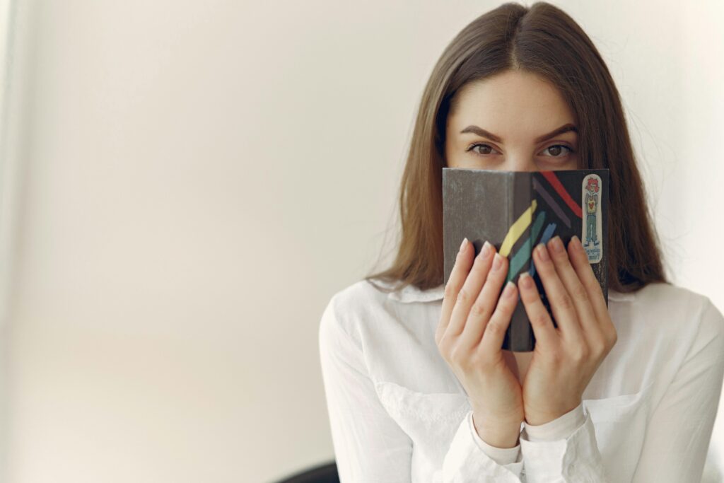 Femme inspirée tenant un cahier, symbolisant une mission secrète pour un épanouissement professionnel