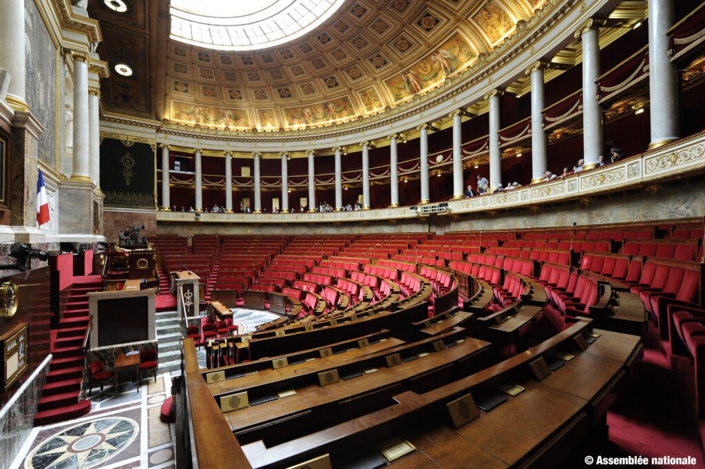 Vue de l’hémicycle de l’Assemblée nationale vide, symbolisant les débats politiques et le leadership de Simone Veil dans les années 70