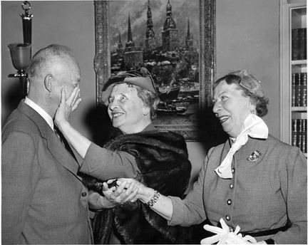 Helen Keller, souriante, serre la main du président Dwight Eisenhower dans le bureau ovale, illustrant son influence et son engagement pour les droits des personnes handicapées.