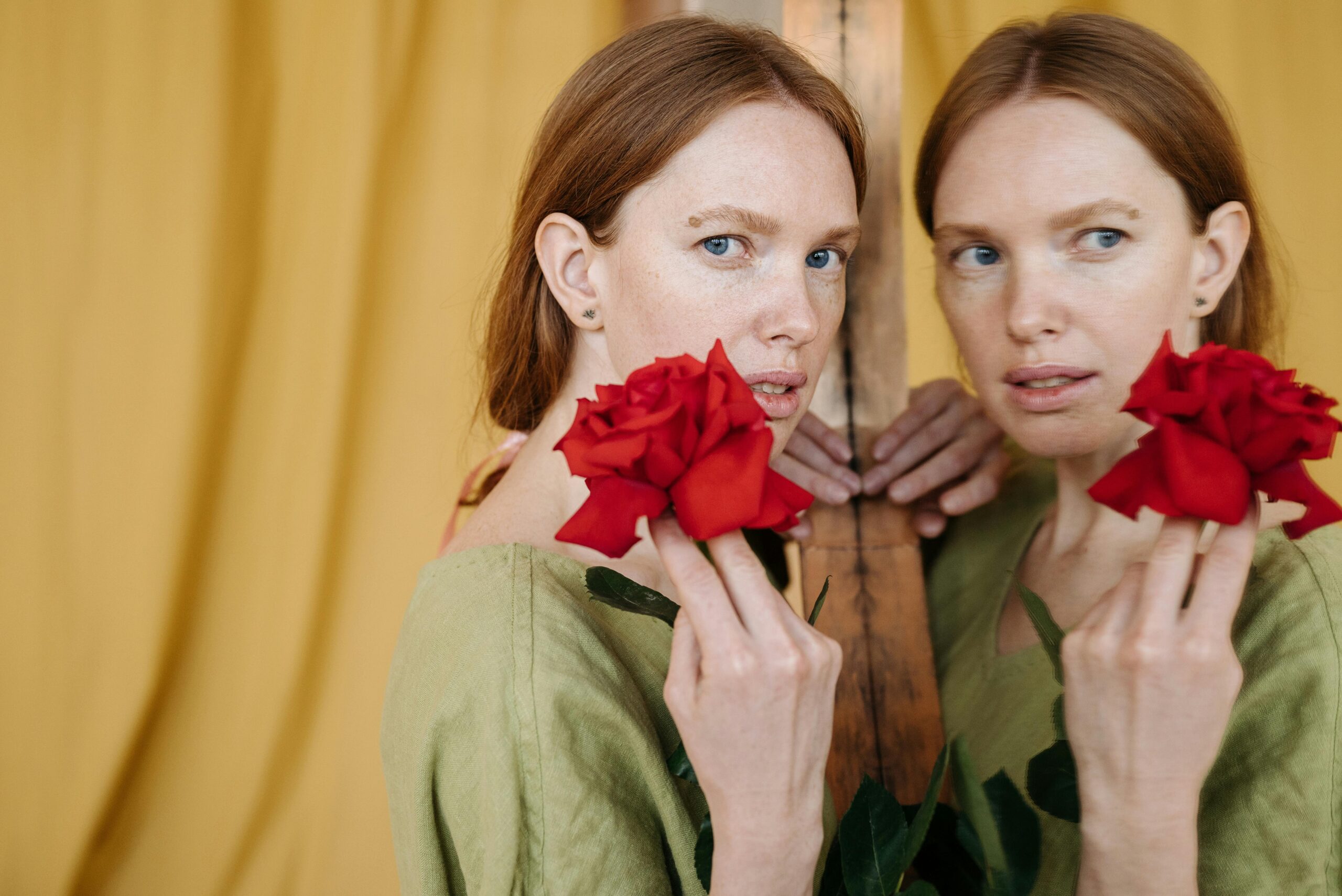 Femme tenant des roses rouges face à son reflet dans un miroir, symbole du pouvoir retrouvé à travers les relations tendues.