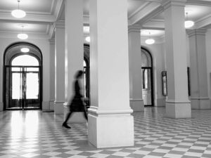Femme en mouvement dans un grand couloir, flou cinétique noir et blanc — reprendre sa vie professionnelle en main